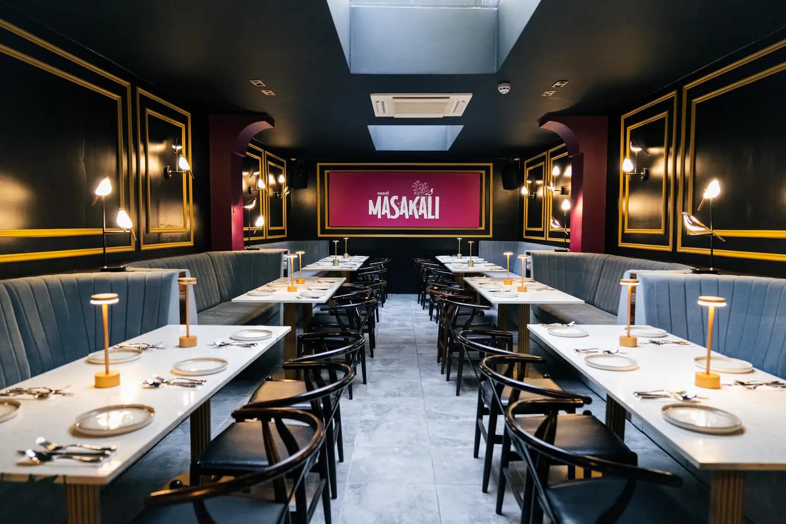 Masakali dining room set for service beneath the lit signage
